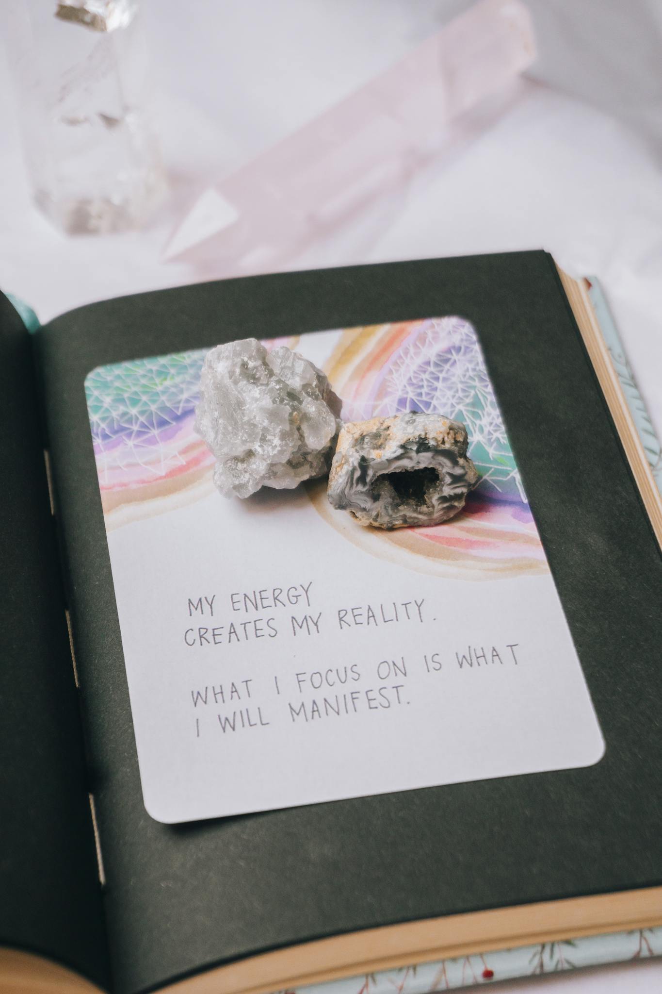 Open journal featuring crystals and an inspiring manifestation quote, perfect for motivation seekers.
